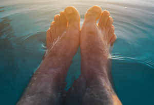 Male feet in outdoor swimming pool